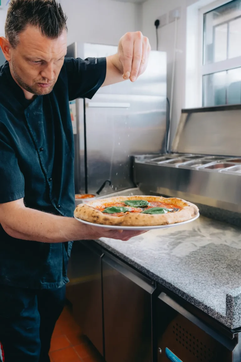 Finishing a freshly baked pizza